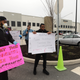 Protesters hold signs saying "Treat your workers like your customers" and "Alexa Please Shutdown and Sanitize the building?" during a March 2020 protest at the Staten Island warehouse.